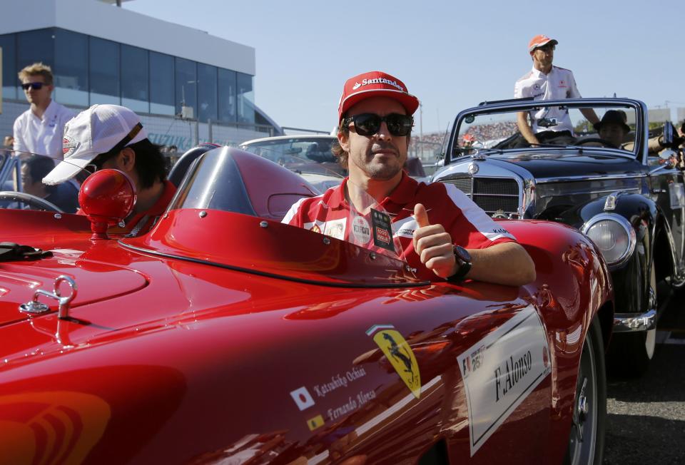 Ferrari Formula One driver Fernando Alonso of Spain gestures during the drivers' parade before the Japanese F1 Grand Prix at the Suzuka circuit October 13, 2013. REUTERS/Toru Hanai (JAPAN - Tags: SPORT MOTORSPORT F1)