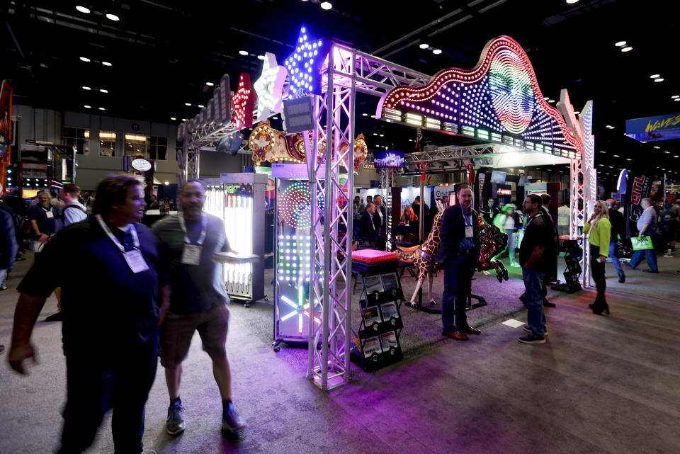 Attendees check out an LED display at the International Association of Amusement Parks and Attractions convention Tuesday, Nov. 19, 2019, in Orlando, Fla. (AP Photo/John Raoux)