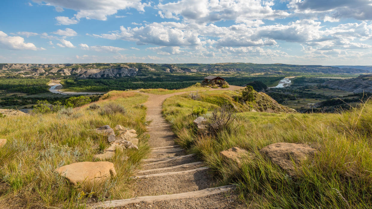 A trail to a scenic overlook of a badlands river valley.