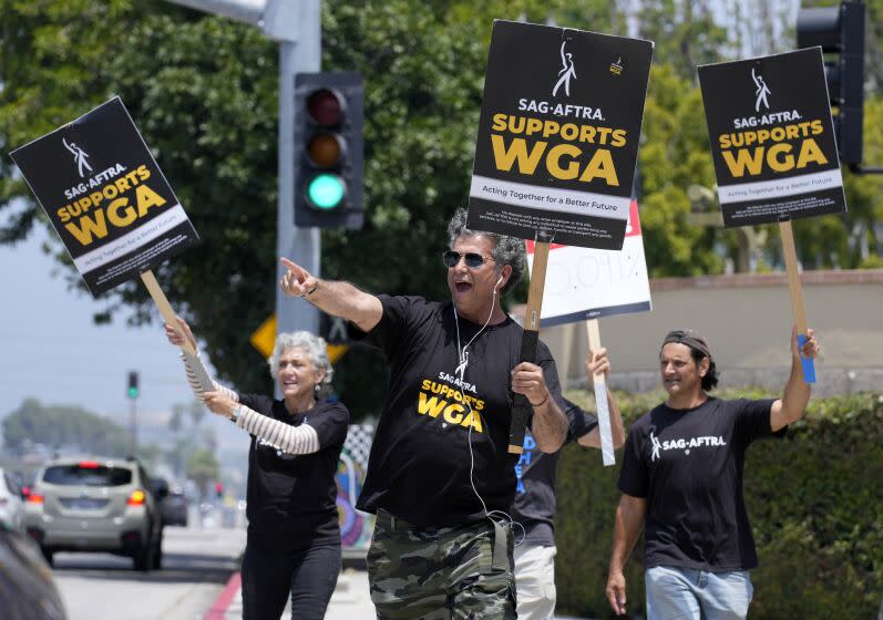 Screen Actors Guild member Dereck Andrade, center, and other SAG members take part in a Writers Guild rally outside Warner Bros. Studios, Monday, May 22, 2023, in Burbank, Calif. (AP Photo/Chris Pizzello)