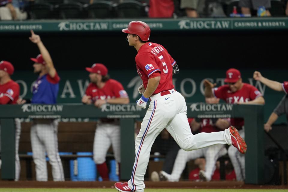 The dugout celebrates as Texas Rangers' Corey Seager (5) reuns the bases after hitting a three-run home run in the fifth inning of a baseball game against the Minnesota Twins, Friday, July 8, 2022, in Arlington, Texas. Josh Smith and Mitch Garver also scored on the shot. (AP Photo/Tony Gutierrez)