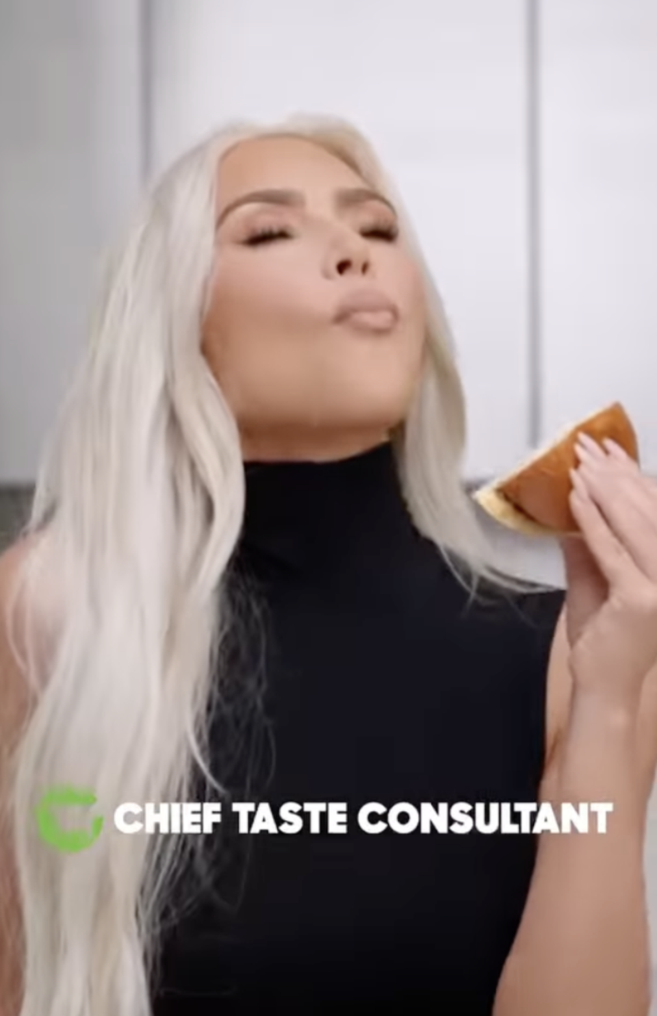 Kardashian appeared to chew while holding up a burger that appeared untouched (Kim Kardashian / Instagram)