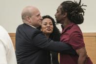 James Irons, right, is embraced by his lawyers David Shanies, left, and Deborah Francois, center, after his exoneration at Brooklyn Supreme Court, Friday July 15, 2022, in New York. (AP Photo/Bebeto Matthews)