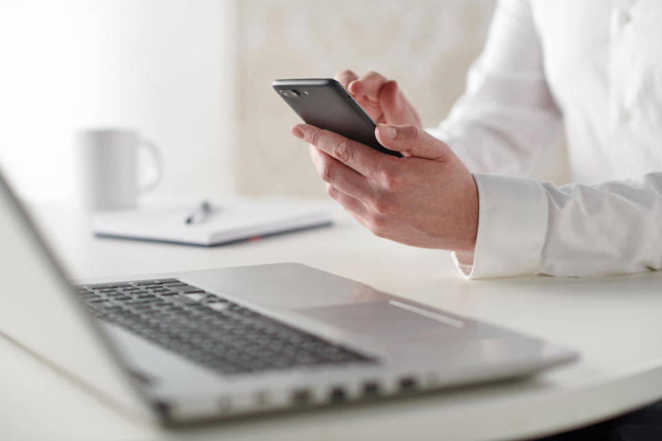 Close up detail of a businessman working at a desk with a smartphone and laptop computer, taken on January 31, 2019. (Photo by Neil Godwin/Future Publishing via Getty Images)