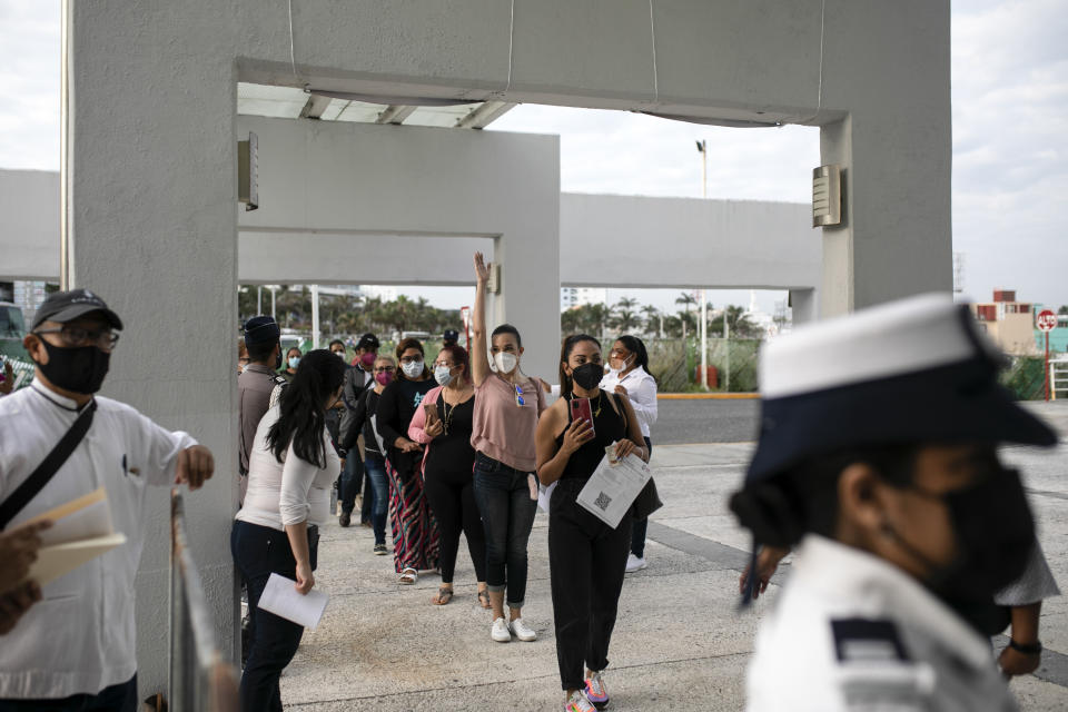 Education workers line up for a jab of the single-dose CanSino COVID-19 vaccine during a vaccination drive at the World Trade Center in Boca del Rio, Veracruz state, Mexico, Tuesday, April 20, 2021. The Mexican government began giving teachers in five other states the single-dose CanSino COVID-19 vaccine to speed up their return to the classroom before the end of the school year in July. (AP Photo/Felix Marquez)