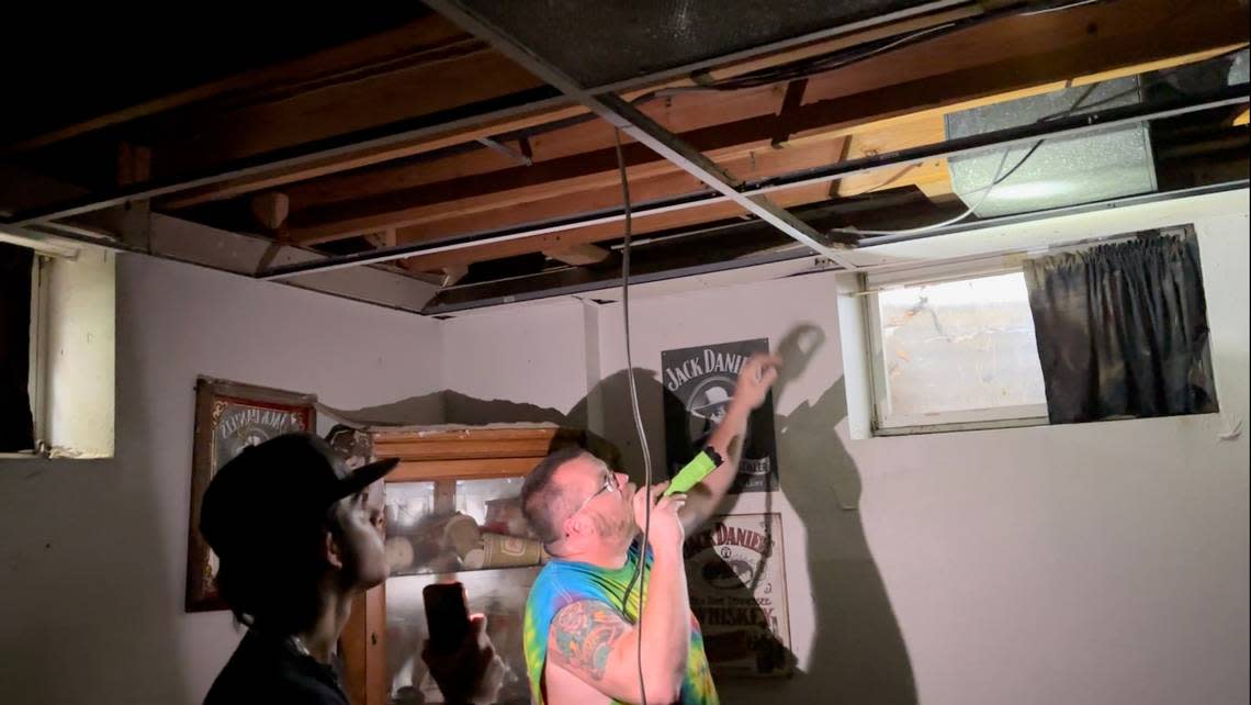 Two members of the Bujnak family investigate the home’s basement on July 17, 2024. The basement was flooded with up to 9 feet of water after heavy rain caused nearby Richland Creek to spill its banks..