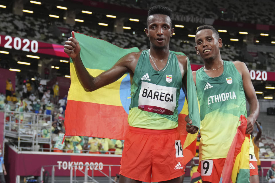 Selemon Barega, of Ethiopia, left, celebrates with compatriot Berihu Aregawi after winning the men's 10,000-meters final at the 2020 Summer Olympics, Friday, July 30, 2021, in Tokyo. (AP Photo/Matthias Schrader,Pool)