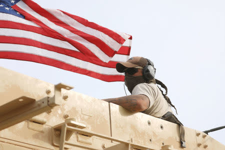 A member of U.S forces rides on a military vehicle in the town of Darbasiya next to the Turkish border, Syria April 28, 2017. REUTERS/Rodi Said