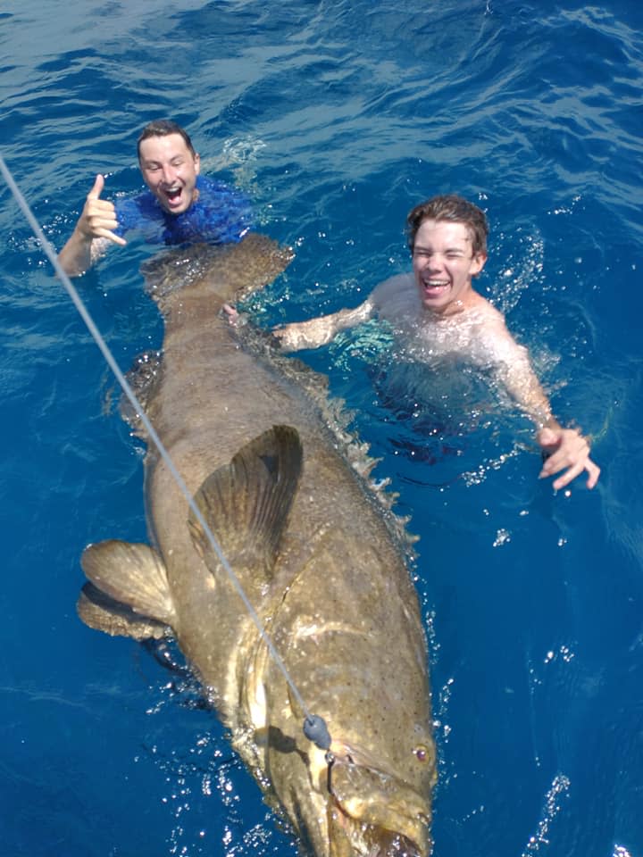 Two anglers enjoy a dip with a goliath grouper they reeled up May 13, 2021, while fishing with Capt. Matt Budd and the Jupiter Fishing Academy. The fish was released.