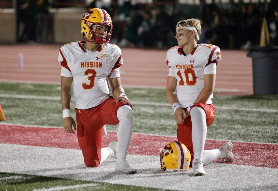 Mission Viejo quarterbacks Luke Fahey, left, and Draiden Trudeau on the sideline during a timeout Friday.