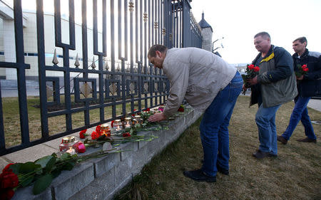 Men lay flowers to commemorate victims of a blast in Russian St.Petersburg metro, at the Russian embassy in Minsk, Belarus April 3, 2017. REUTERS/Vasily Fedosenko