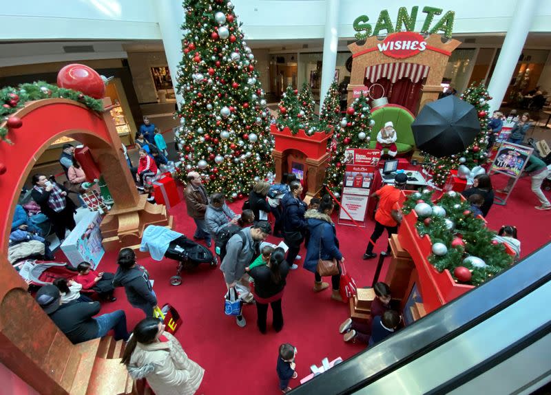 FILE PHOTO: Families wait in line to meet Santa Claus at Fashion Centre at Pentagon City, decorated for the holidays, in Arlington, Virginia
