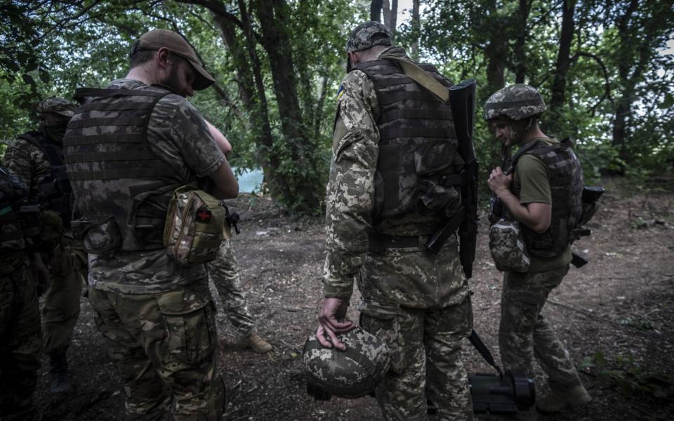 Ukrainian servicemen gather in woodlands near the frontlines of Izium, south of Kharkiv, on 8 June 2022. - Maria Senovilla/Shutterstock