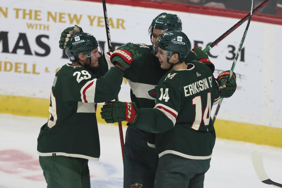 Minnesota Wild center Joel Eriksson Ek (14) celebrates with teammates after scoring a goal during the first period of the team's NHL hockey game against the Arizona Coyotes, Tuesday, Nov. 30, 2021, in St. Paul, Minn. (AP Photo/Stacy Bengs)