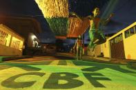 A boy jumps rope on Third Street of the Alvorada neighbourhood, which is painted with the logo of the Brazilian Soccer Confederation (CBF) and decorated for the 2014 World Cup, in Manaus, one of the tournament's host cities, May 17, 2014. The World Cup will be held in 12 cities across Brazil from June 12 through July 13. REUTERS/Bruno Kelly (BRAZIL - Tags: BUSINESS LOGO SOCIETY SPORT SOCCER WORLD CUP TPX IMAGES OF THE DAY)