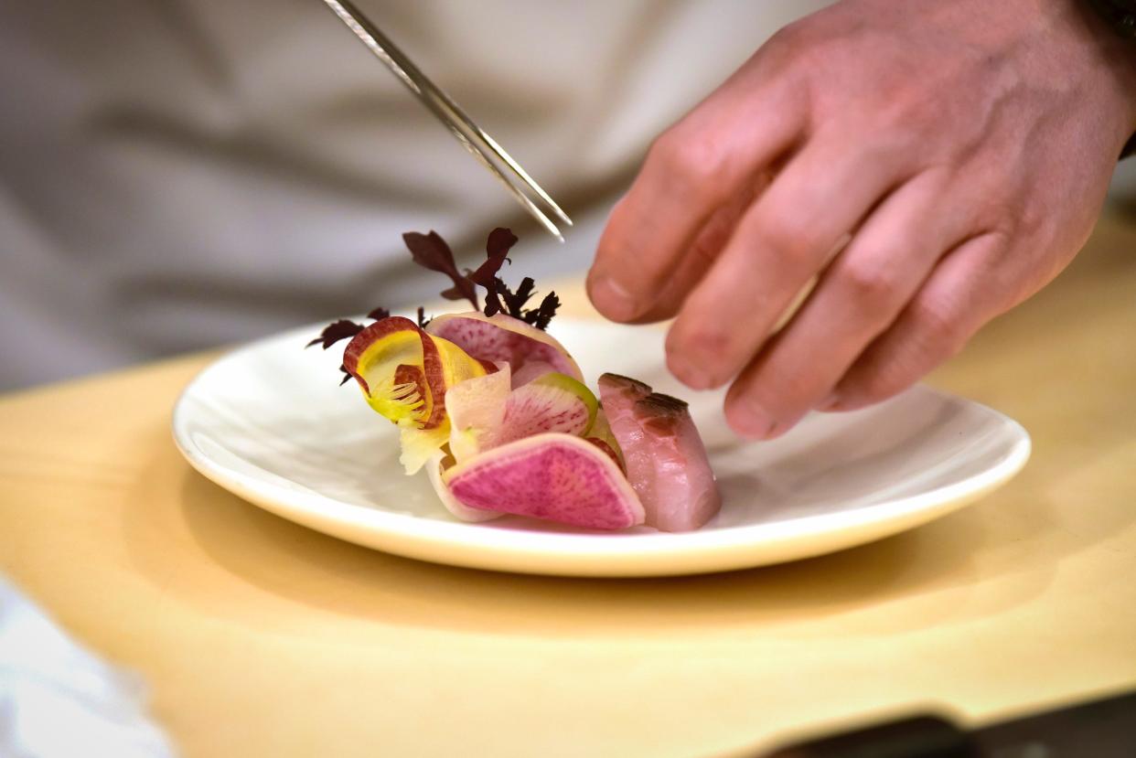 Sushi Chef Sung Kim prepares a dish of salad at Sushi Kai in Fort Lee on Tuesday, March 1, 2022.