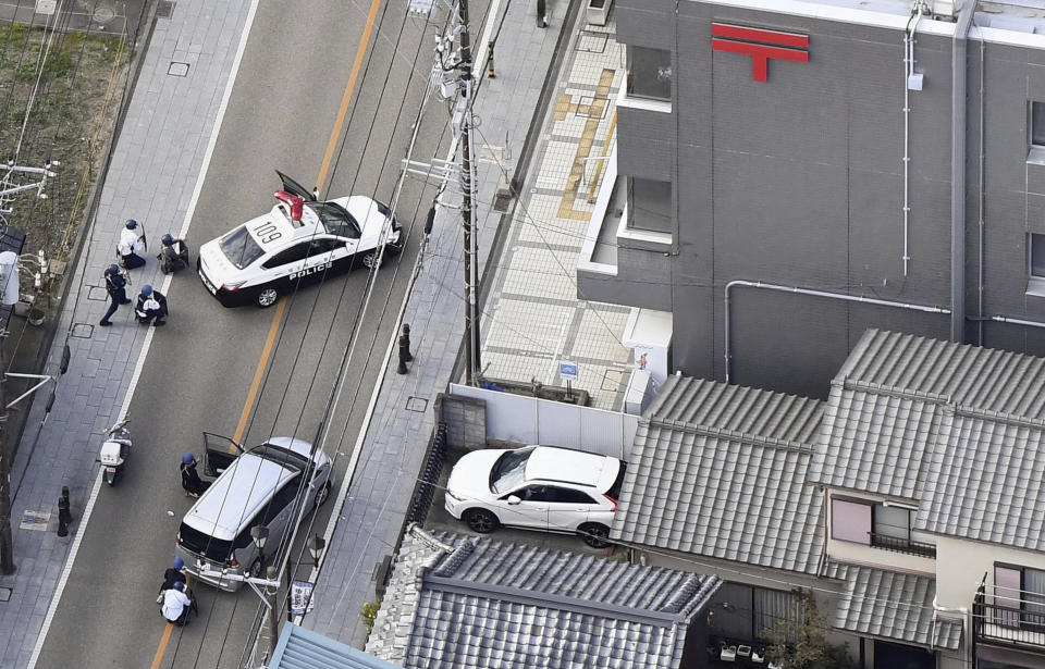 This aerial photo shows first responders take position outside the post office where a man is believed to hole up in Warabi city, Saitama prefecture, north of Tokyo, Tuesday, Oct. 31, 2023. (Kyodo News via AP)