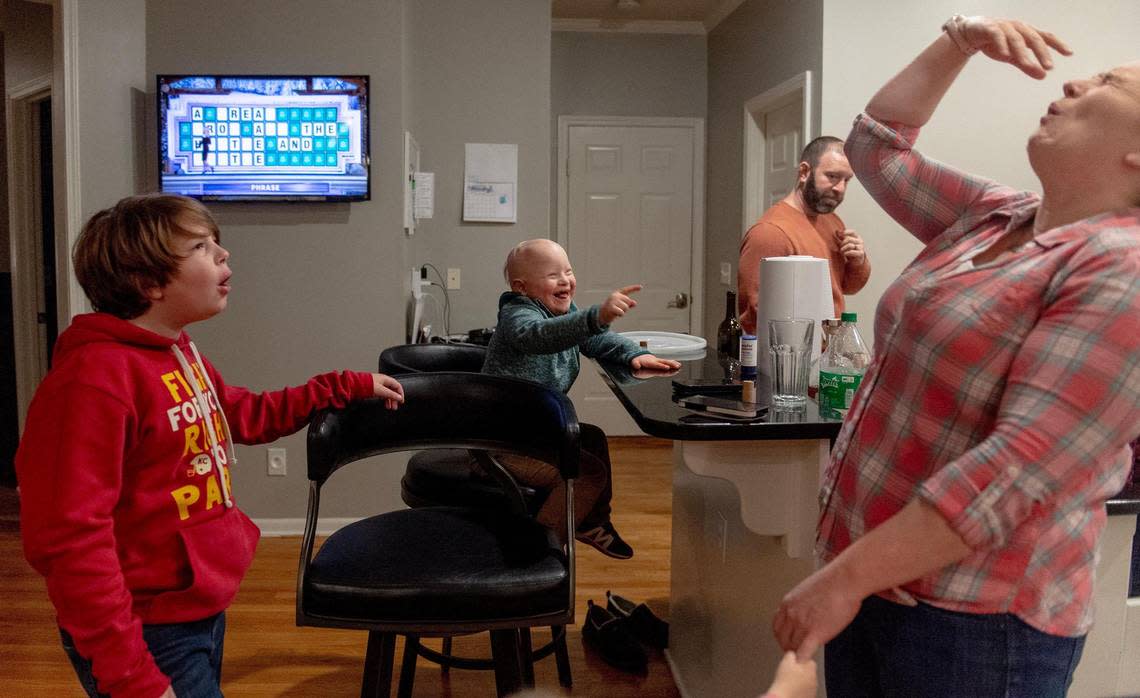 Johnson County mom Sara Jahnke exaggerates a reaction to a high five from her son, Crosby Orlando, as they gather for supper at a friend’s house in Shawnee.