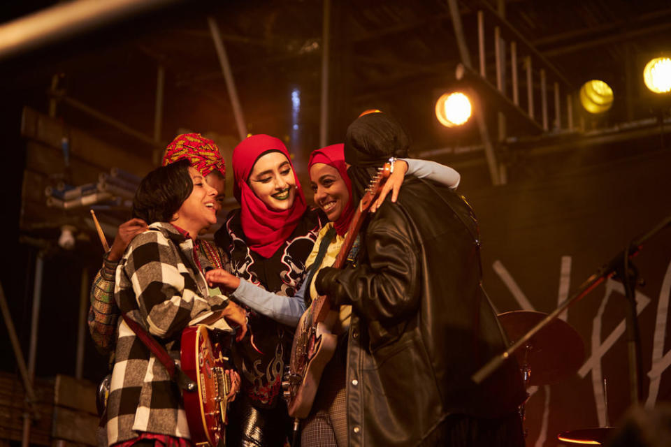 Sarah Kameela Impey, Faith Omole, Juliette Motamed, Anjana Vasan, and Lucie Shorthouse huddle with instruments onstage