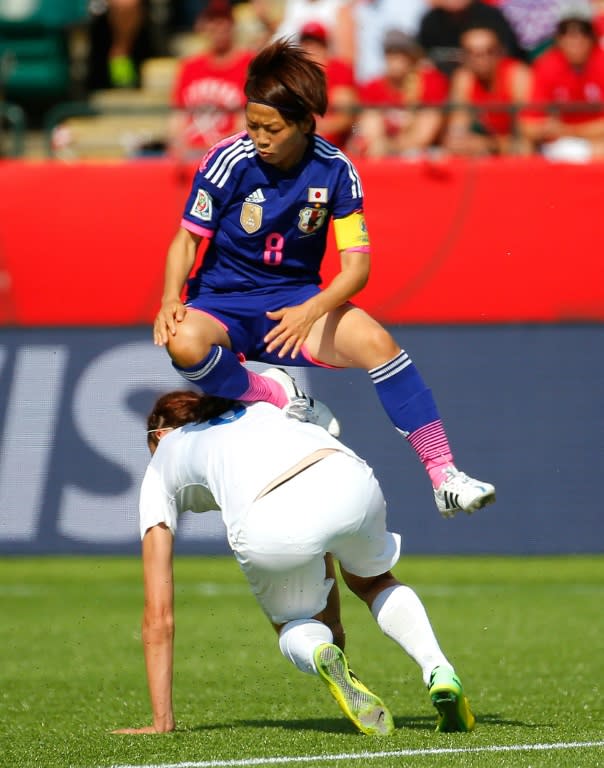 Aya Miyama of Japan leaps over Jill Scott of England during their FIFA Women's World Cup match, at Commonwealth Stadium in Edmonton, Canada, on July 1, 2015