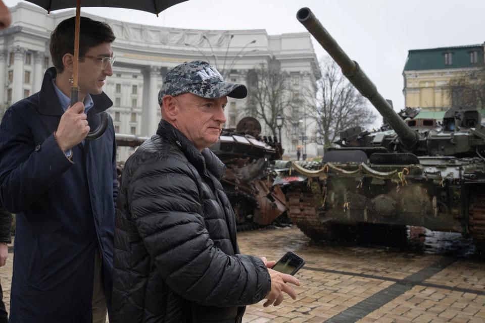Sen. Mark Kelly (D-Ariz.) passes by a damaged Russian tank exhibition in central Kyiv, Ukraine, on April 12, 2023.