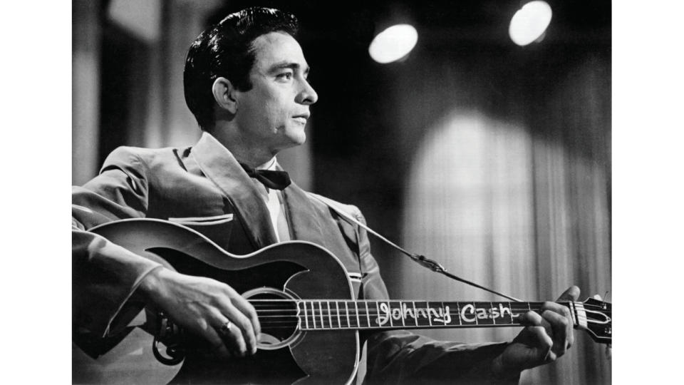 Johnny Cash with his custom  Gibson J-200, in 1957. Note the  oversized pickguard.