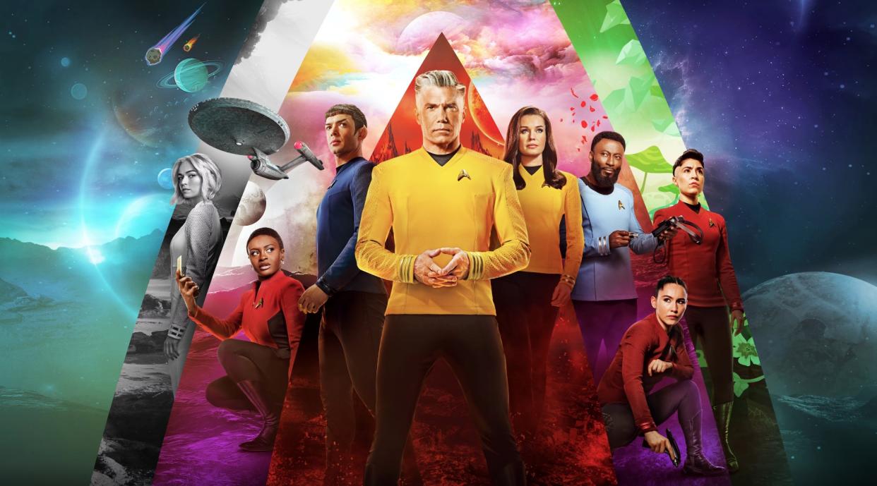  Eight star trek characters stand in front of a spacey background featuring planets and streaking meteors. 