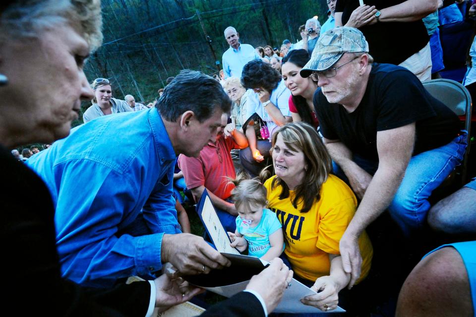 Then-Gov. Joe Manchin gives a state certificate to the family of Josh Napper, one of 25 coal miners killed in an explosion, at a candlelight vigil in Cabin Creek, W.Va., in 2010.