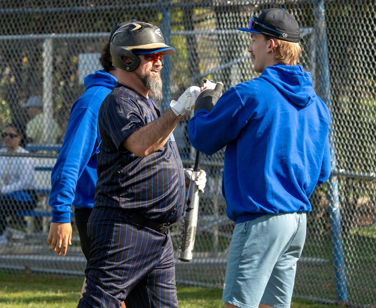 Quinsigamond's Paul Landry gets fist bumps after batting in the third inning.