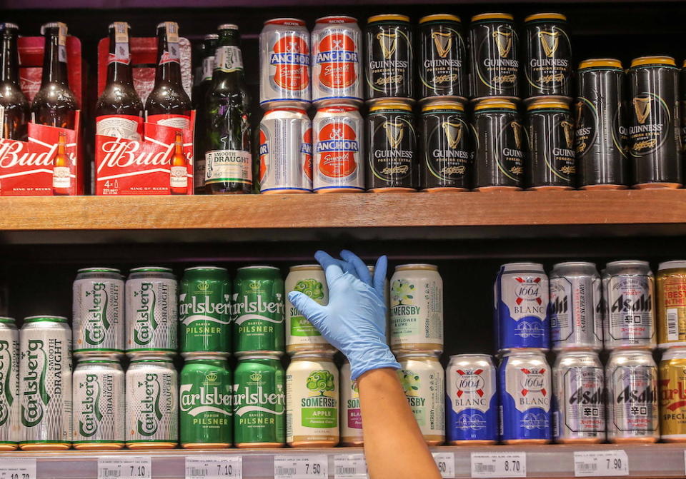 A Jaya Grocer staff arranging cans of beer in Ipoh. — Picture by Farhan Najib