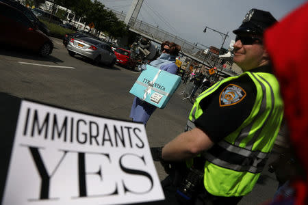 Protesters hold signs near the Intrepid Sea, Air & Space Museum ahead of an expected visit by U.S. President Donald Trump in the Manhattan borough of New York City, U.S. May 4, 2017. REUTERS/Shannon Stapleton