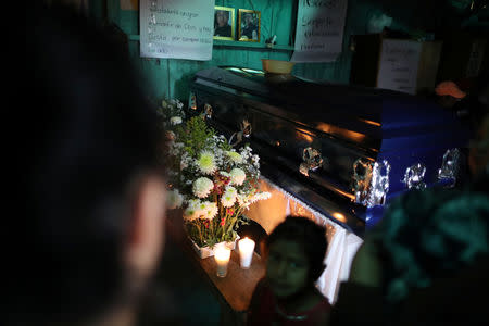 The coffin of Misael Paiz, 25, lies inside his family home before his funeral in Aguacate, Huehuetenango, Guatemala, October 29, 2018. REUTERS/Lucy Nicholson