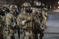 In this photo provided by Doug Brown, agents from different components of the Department of Homeland Security are deployed to protect a federal courthouse in Portland, Ore., Sunday, July 5, 2020. Protesters who have clashed with authorities in Portland are facing off not just against city police but a contingent of federal agents who reflect a new priority for the Department of Homeland Security: preventing what President Donald Trump calls "violent mayhem." The agents clad in military-style uniforms include members of an elite Border Patrol tactical unit, and their deployment to protect federal buildings and monuments is a departure for an agency created to focus on threats from abroad. (Doug Brown via AP)