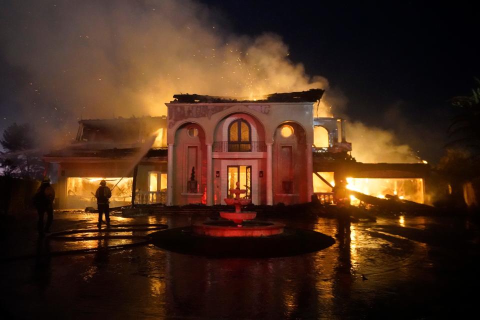 Firefighters work to put out a structure burning during a wildfire Wednesday, May 11, 2022, in Laguna Niguel, Calif.