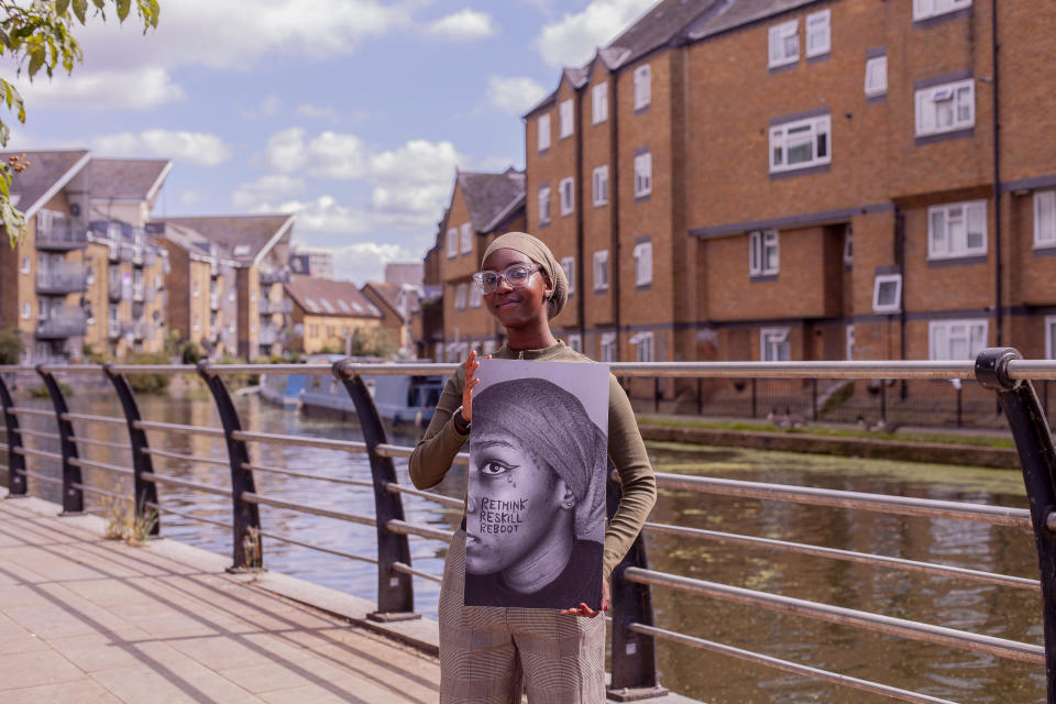 Teenager Fawziya Haji holds up a self-portrait, a stark black and white image of half her face with the words ‘Rethink Reskill Reboot’ daubed in ink on her cheek. (Supplied)