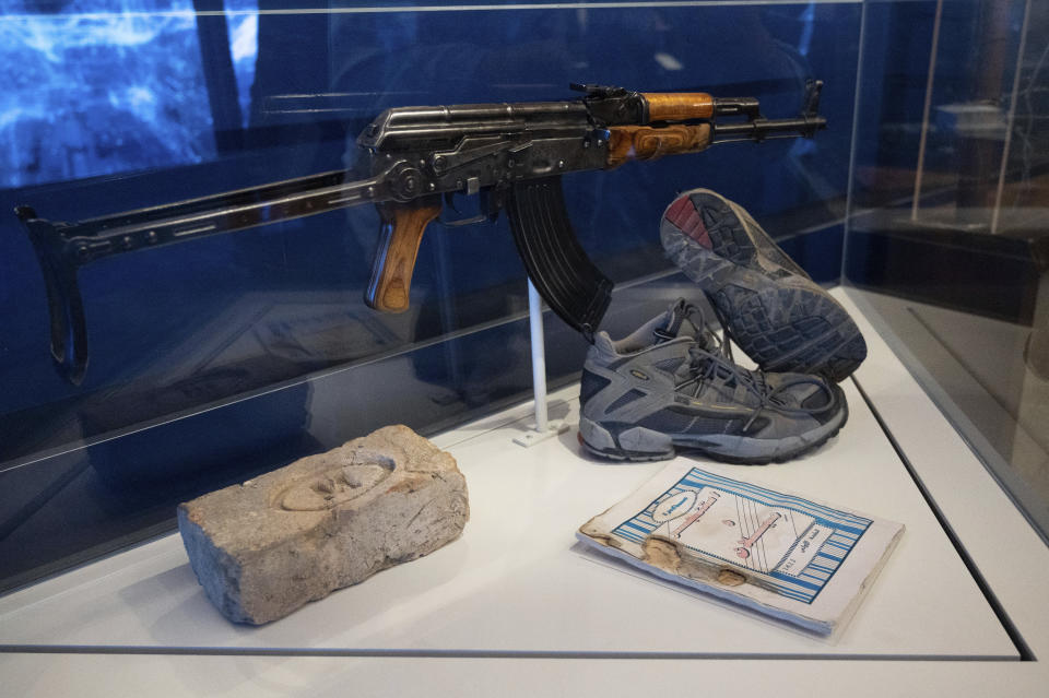 An AKM rifle that was found near the body of Usama Bin Laden during the raid on his compound in Abbottabad, Pakistan, is on display with a brick from the compound in the refurbished museum in the CIA headquarters building in Langley, Va., Saturday, Sept. 24, 2022. (AP Photo/Kevin Wolf)