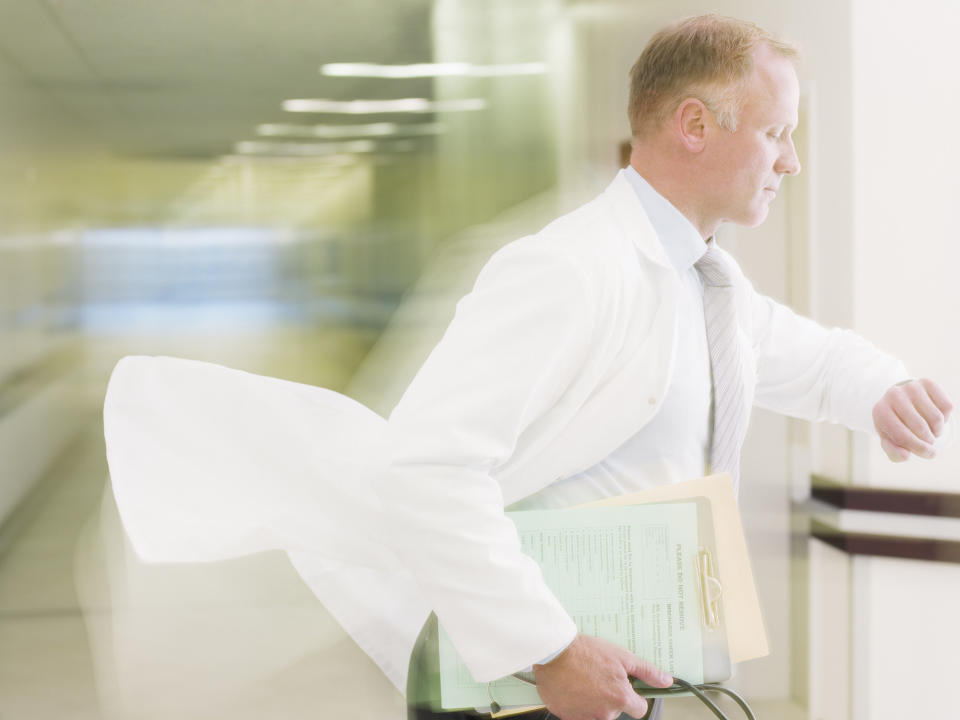 A doctor looking at his watch in a rush