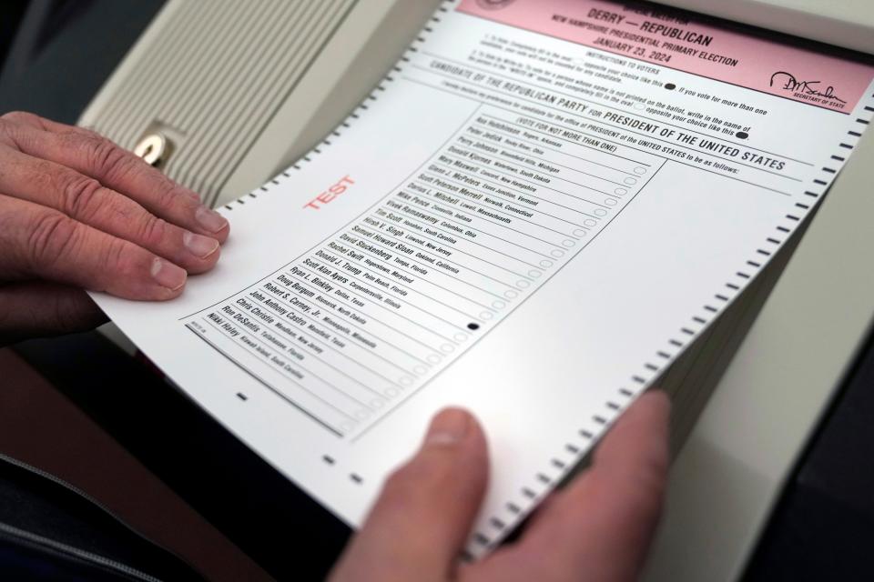 Lynne Gagnon, Derry, New Hampshire deputy town clerk, left, unloads test ballots from a storage cart as Tina Guilford, Derry town clerk, prepares to load them into the ballot counting machine again while testing the machines ahead of the New Hampshire primary, at the Derry Municipal Center, Tuesday, Jan. 16, 2024.