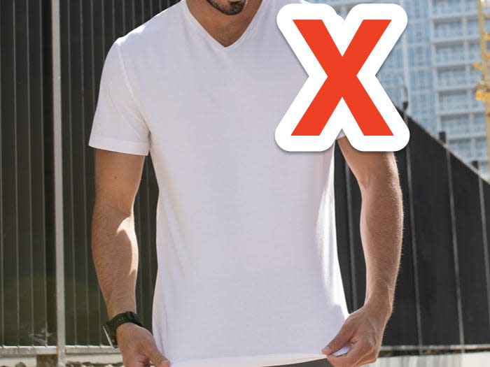 red x over man wearing white v neck t shirt over khaki shorts