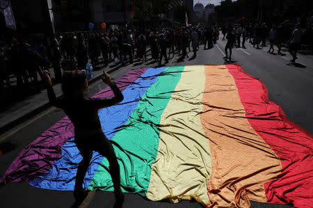 A participant dances in front of a rainbow flag during an annual LGBT (Lesbian, Gay, Bisexual and Transgender) pride parade in Belgrade, Serbia September 17, 2017. REUTERS/Marko Djurica