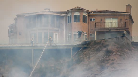 Firefighters defend a home on September 2, 2017 in Los Angeles, California.