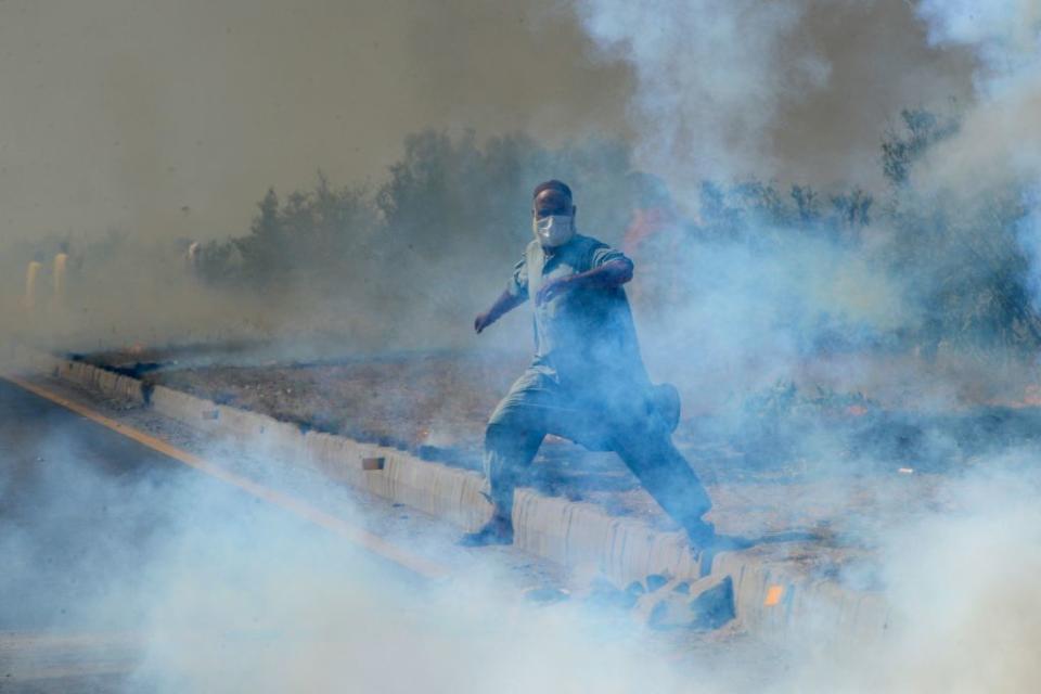 A supporter of Pakistan's former prime minister Imran Khan amid tear gas fired by police during a protest rally in Swabi on May 25.<span class="copyright">Abdul Majeed—AFP/Getty Images</span>