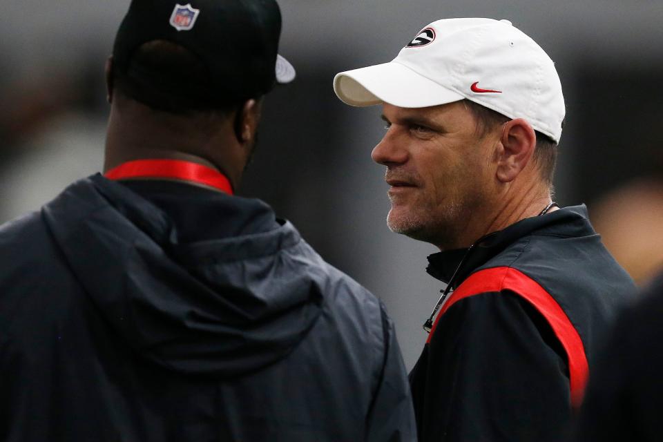 Georgia football analyst Mike Bobo speaks with an NFL scout during Georgia's Pro Day in Athens, Ga., on Wednesday, March 16, 2022.