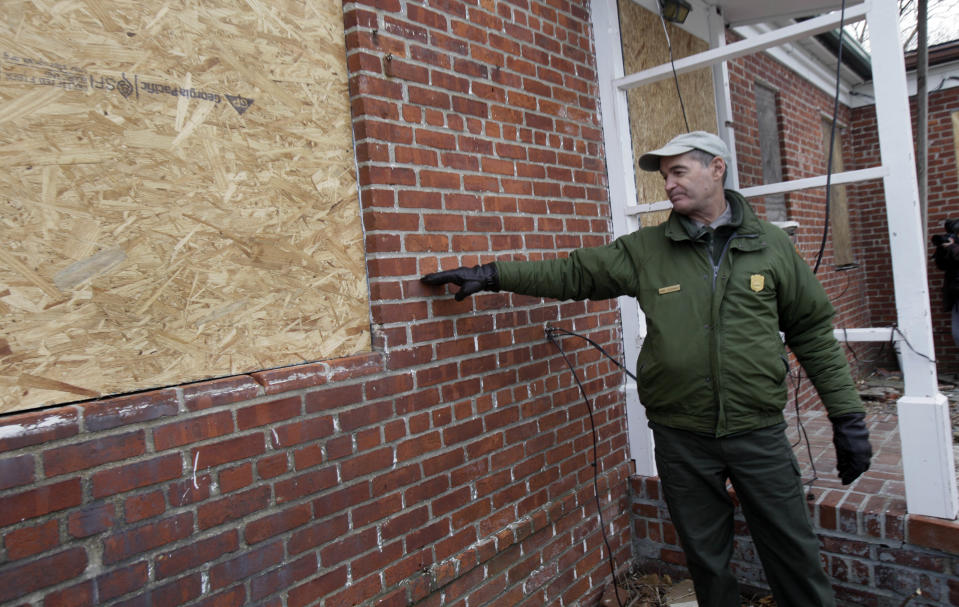 David Luchsinger, superintendent of Statue of Liberty National Monument, and last resident of Liberty Island, shows the high water line at the back of his Superstorm Sandy-damaged home, on Liberty Island in New York, Friday, Nov. 30, 2012. Tourists in New York will miss out for a while on one of the hallmarks of a visit to New York _ seeing the Statue of Liberty up close. Though the statue itself survived Superstorm Sandy intact, damage to buildings and Liberty Island's power and heating systems means the island will remain closed for now, and authorities don't have an estimate on when it will reopen. (AP Photo/Richard Drew)