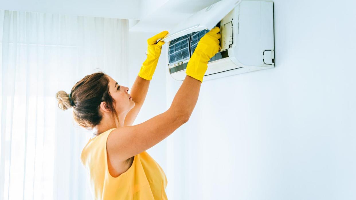 Woman cleaning air conditioning