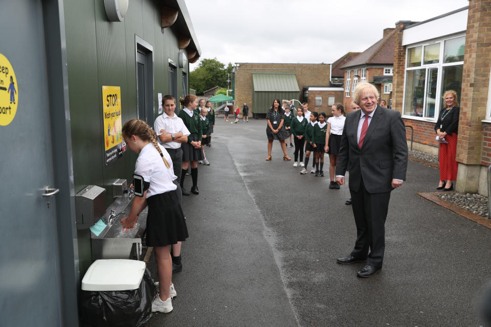 BOVINGDON, ENGLAND - JUNE 19: Prime Minister Boris Johnson waits in line in the playground to wash his hands during a visit to Bovingdon Primary School on June 19, 2020 near Hemel Hempstead. The Government have announced a GBP 1 billion plan to help pupils catch up with their education before September after spending months out of school during the coronavirus lockdown. (Photo by Steve Parsons - WPA Pool/Getty Images)