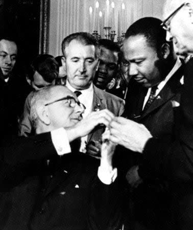 On July 2, 1964, U.S. President Lyndon B. Johnson signed the Civil Rights Act of 1964, with King and other civil rights leaders present. (File photo/AP)