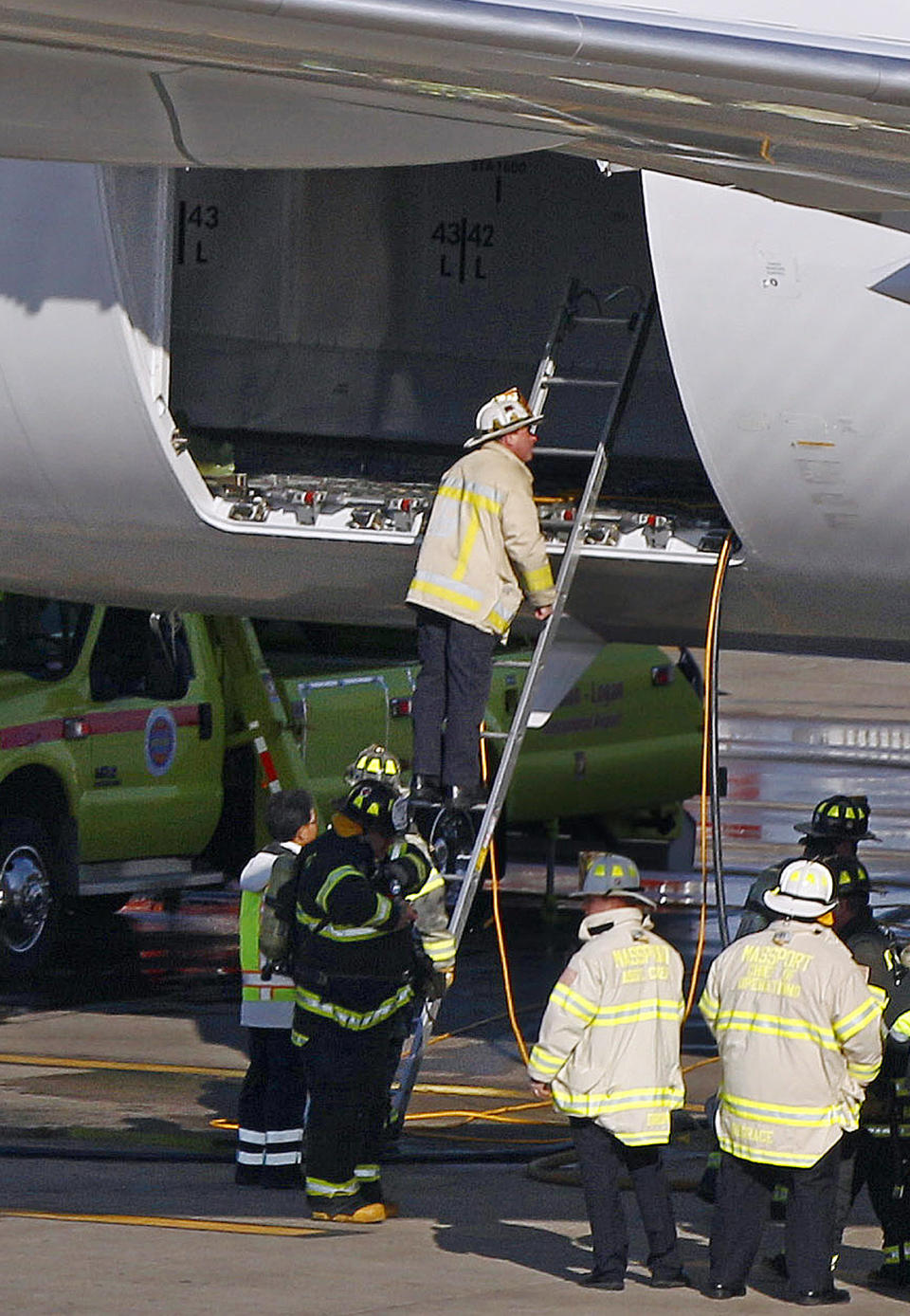 A Boston Fire Department chief looks into the cargo hold of a Japan Airlines Boeing 787 Dreamliner jet parked at a Terminal E gate at Logan International Airport in Boston, Monday, Jan. 7, 2013. A small electrical fire filled the cabin of the JAL aircraft with smoke Monday morning about 15 minutes after it landed in Boston. (AP Photo/Stephan Savoia)