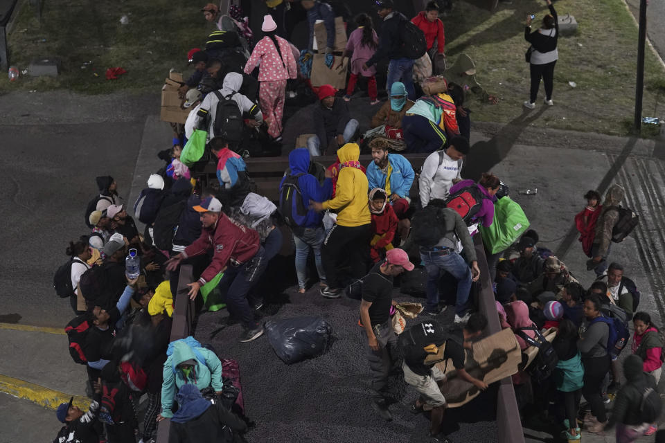 Migrants hop a northbound freight train in Irapuato, Mexico, Saturday, Sept. 23, 2023. (AP Photo/Marco Ugarte)