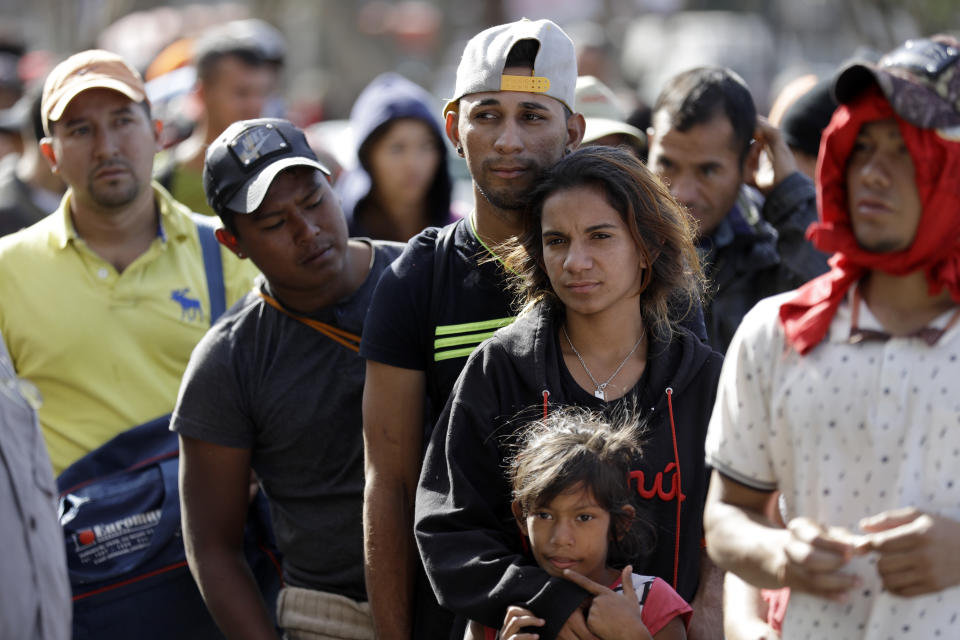 Marvin Ochoa, center, of Honduras, waits in line for a meal behind his wife, Diana Marylin Ochoa, after they arrived with a Central American migrant caravan in Tijuana, Mexico, on Nov. 15, 2018. (Photo: Gregory Bull/AP)